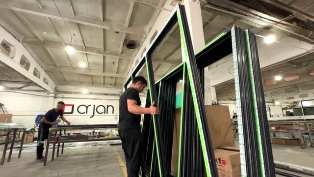 Сотрудник ArJan с оконной рамой на производстве